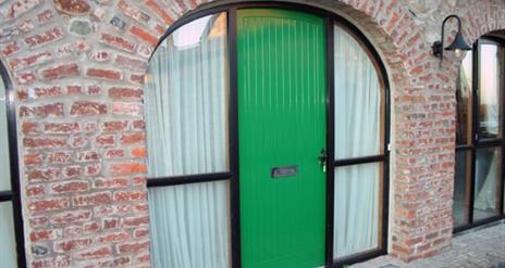 A green door in a arch way