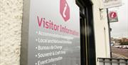 A close up photo of the Visitor Information sign beside the front door of Tower House
