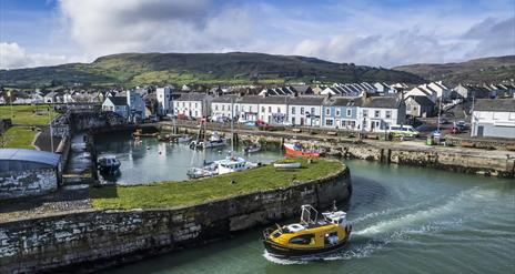 Curiosity boat leaving historical Carnlough harbour