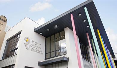 Photo of the front of the building. Windows and white walls with large 'R' logo and text reading "Roe Valley Arts and Cultural Centre". There are also