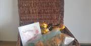 Wicker hamper basket with buns chocolate and a card