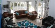 living area with sofas and armchairs, floor length windows and patio doors
