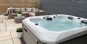 enclosed garden area with seating and hot tub