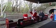 a man dressed as santa on the small train