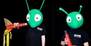 Image show 2 children with bug heads on and wearing Island Arts Centre t-shirts