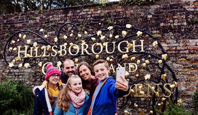 Family take a selfie at the Hillsborough Castle and Gardens sign