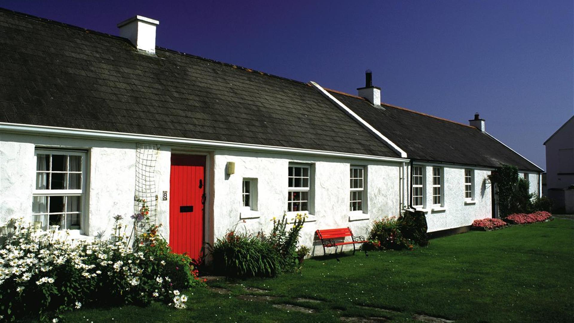 a photograph of the exterior of some terraced white cottages