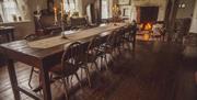 long wooden dining table with candles on table runner