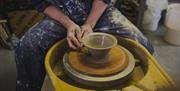 Shaping a clay on the pottery wheel