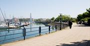 Image of the promenade mid summer, taking you round the marina. Image shows the visiting Big Wheel attraction.