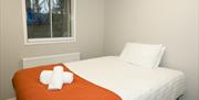 Double bed with white and orange linen