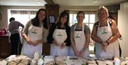 A group of four ladies pose for the photo whilst making soda bread