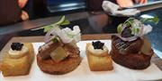 Image is of 4 different desserts placed on a napkin on a table