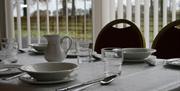 dining table set with cream tableware and 2 chairs