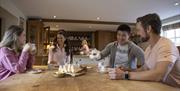 group of 4 adults, 2 male and 2 female enjoying tea baked soda bread at a table in Tracey's Kitchen