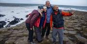 Tour group take a selfie on the basalt rocks of the Giants Causeway