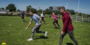 Group run alongside Ross Carr practising the new skills they've learnt during the Gaelic Games and Craic session