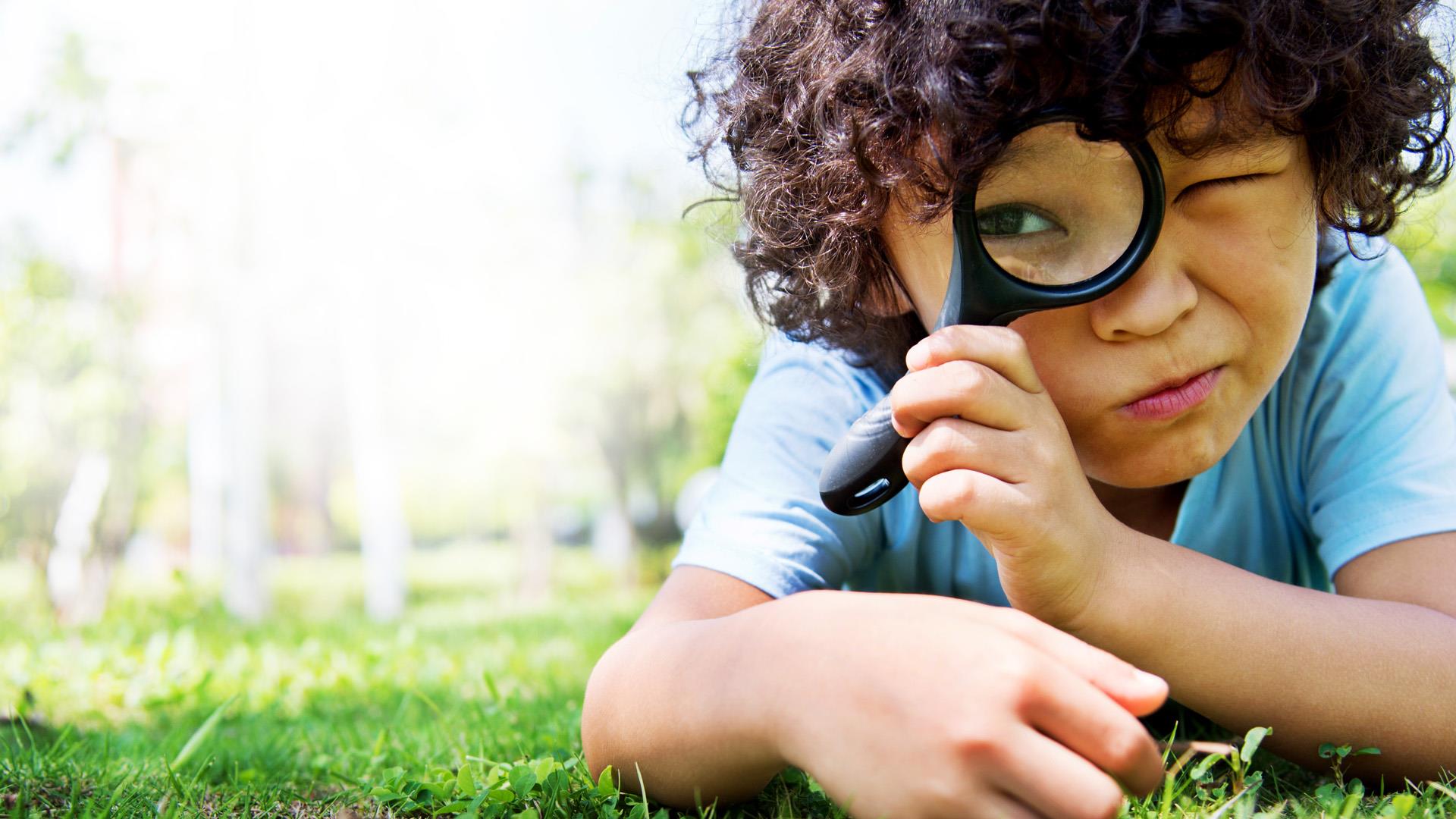 A child looking through a magnifying glass