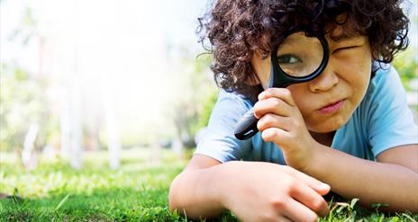 A child looking through a magnifying glass