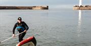 A stand up paddleboarder in Donaghadee Harbour