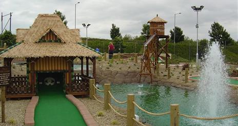 Image shows golf putting area with small lake and fountain