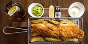 Fish and Chips in basket with accompaniments