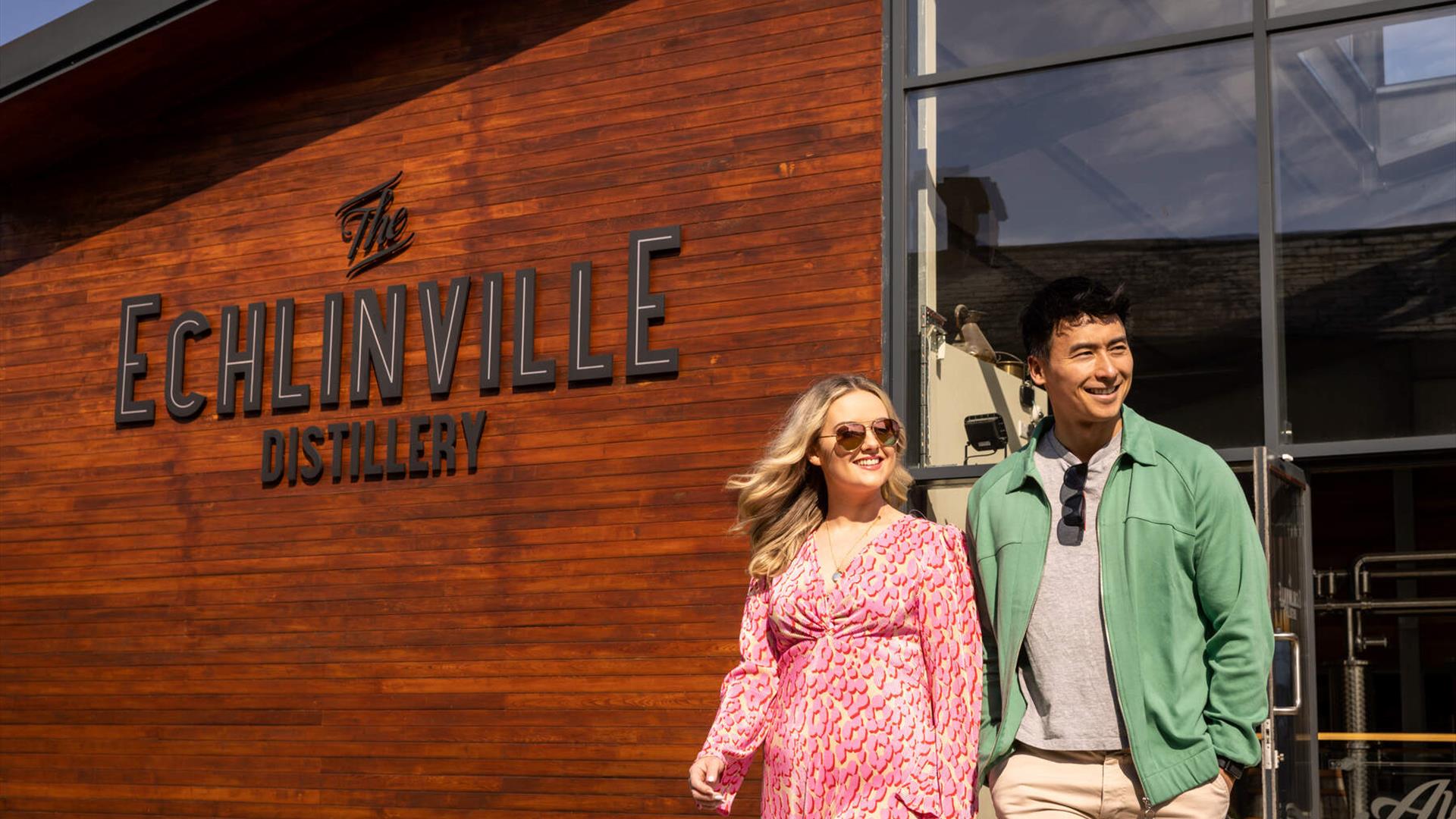 Couple walks outside the Echlinville Distillery in the sunshine