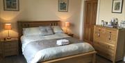 Image of a double bed with bedside tables and a chest of drawers
