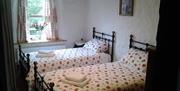 twin room with 2 single beds with red and white linen
