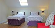 Image shows twin bedroom with skylight and sofa bed