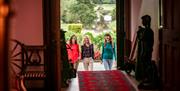 Three girls walking through the doors of Killymoon Castle