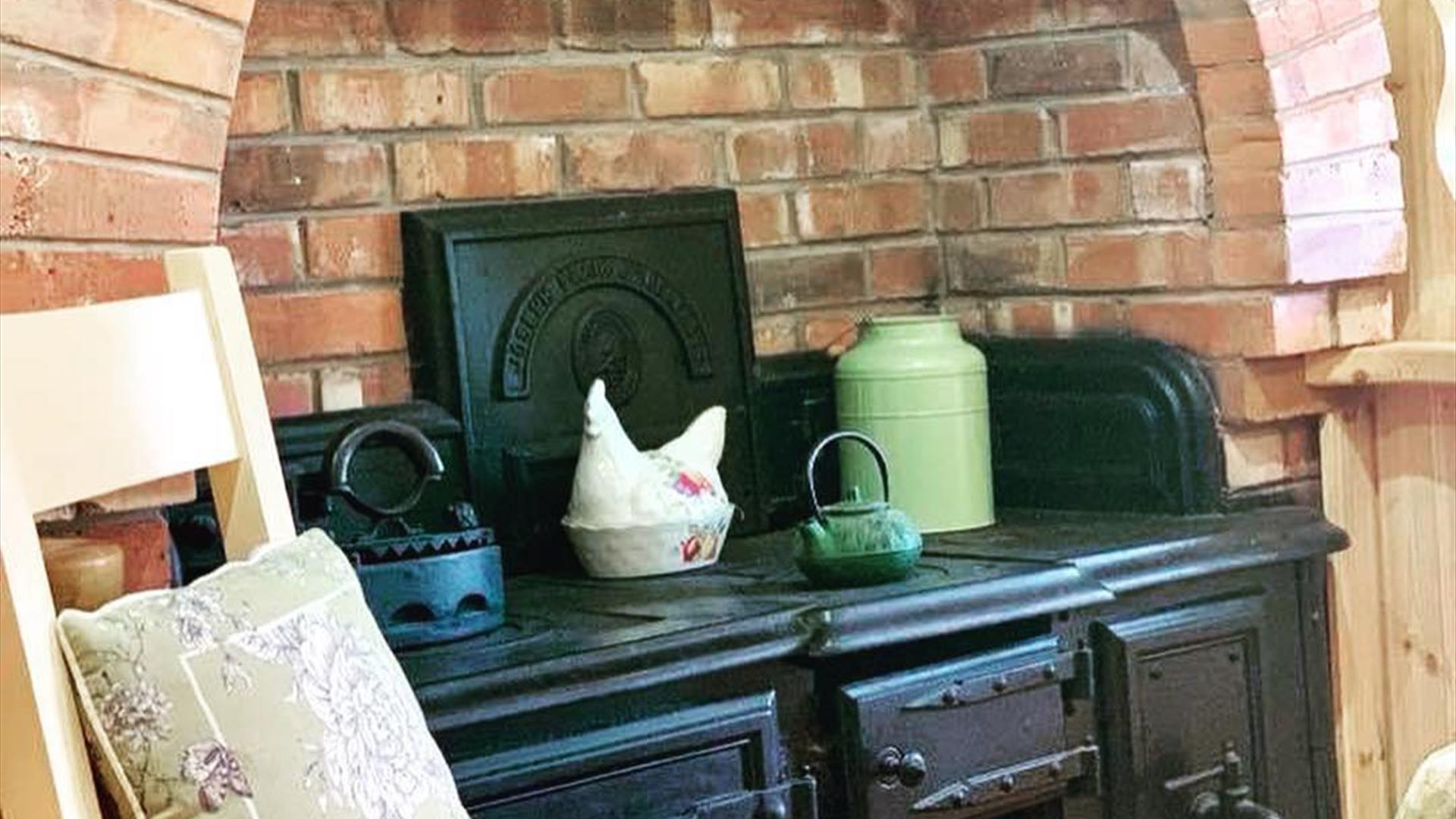 Image shows Aga in kitchen area with explosed brickwork surrounding it