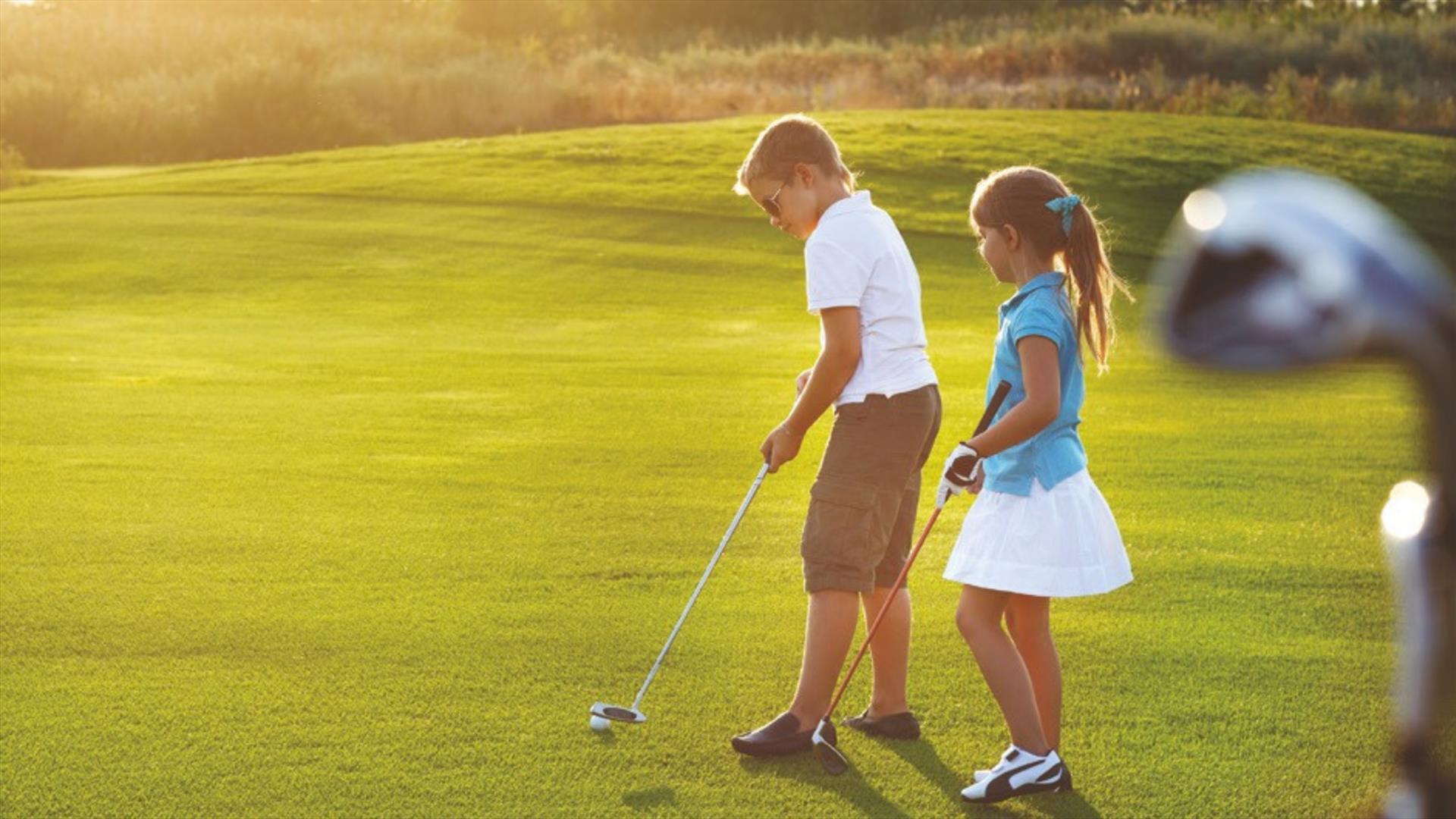 A young boy and a girl playing golf.