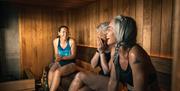 Three ladies laughing as they enjoy a sauna together