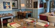 An image of the indoor dinning area at the Speckled hen showing the table, chairs and place settings.