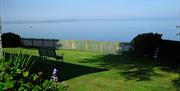 Enclosed garden with lawn, flowerbeds and summerseat looking onto the ocean.