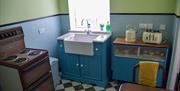 1960s style kitchen containing cooker, sink and cupboards