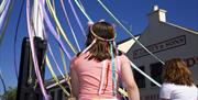 A photo of a little girl with ribbon head dress taking part in the annual Maypole Dancing round the May Pole in Holywood