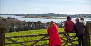 Family standing over a gate looking at the fabulous view of the Islands on Strangford Lough, from Grey Point Lookout at Delamont Country Park.