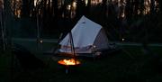 Outdoor Night shot of Lodge teepee camping ground with fire pit