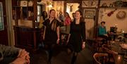 Two Irish dancers showing the group how to do Irish dancing as part of the Ceili & Craic experience at The Ponderosa.
