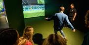 Group enjoying an interactive virtual football session as part of a behind the scenes guided tour of Windsor Park with the Irish Football Association