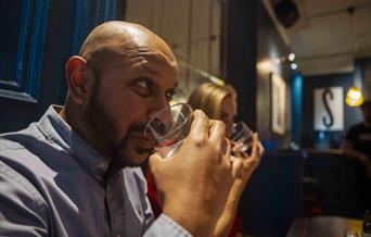 Guests taste mystery liquids during the Sensorium experience