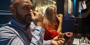 Guests hold their nose during a taste test on the Sensorium experience