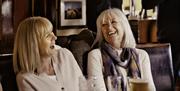 Two females laughing and enjoying a drink at The Maypole Bar