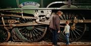 A man and boy looking at a vintage train
