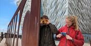 Visitors taking pictures with Konica Pop cameras at the Titanic sign, Belfast.