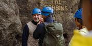 Guide helps secure a man's helmet which is required on The Gobbins cliff path