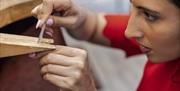 Filing down a piece of silver for her jewellery