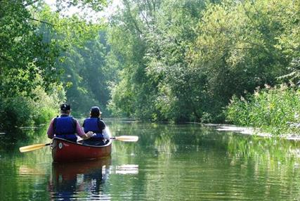 Couple canoeing on the Broads in north Norfolk